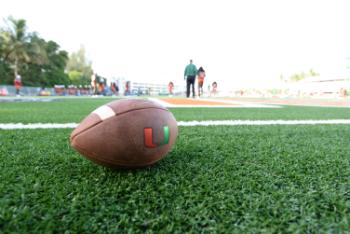 football on the field with "U" logo